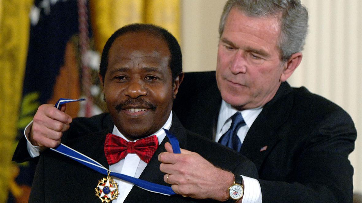 Paul Rusesabagina being handed a medal by US former president George Bush . (KT press)